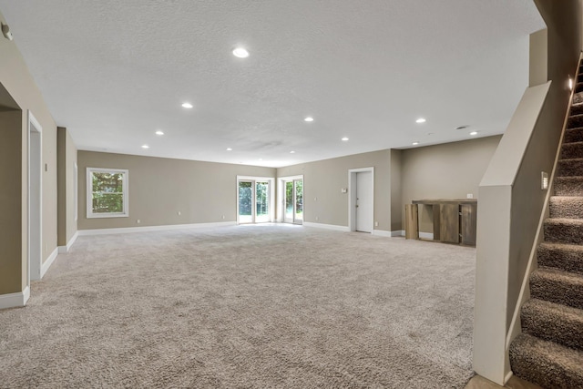 18141 87th Ave N, Maple Grove, MN 55311 - unfurnished living room featuring light carpet, stairs, recessed lighting, baseboards, and a textured ceiling