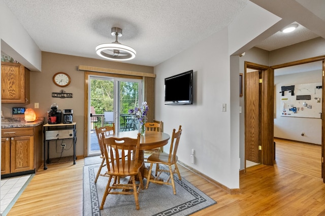2196 Waukon Ave, Saint Paul, MN 55119 - dining room featuring light wood-type flooring, baseboards, and a textured ceiling