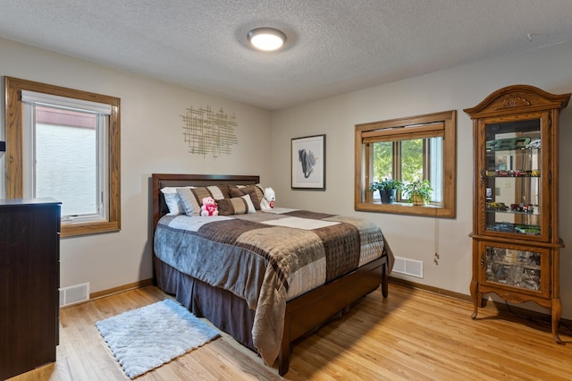 2196 Waukon Ave, Saint Paul, MN 55119 - bedroom featuring light wood-type flooring, baseboards, and a textured ceiling