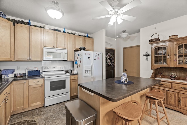 5445 Boone Ave N Unit 216, New Hope, MN 55428 - kitchen featuring white appliances, dark countertops, a kitchen breakfast bar, light brown cabinets, and a ceiling fan