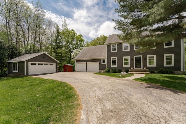 9420 Fabian St NE, Kalmar Twp, MN 55920 - colonial home featuring a garage, a front yard, an outbuilding, and a shingled roof
