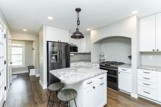 9420 Fabian St NE, Kalmar Twp, MN 55920 - kitchen featuring range with two ovens, fridge with ice dispenser, built in microwave, a breakfast bar, and a center island