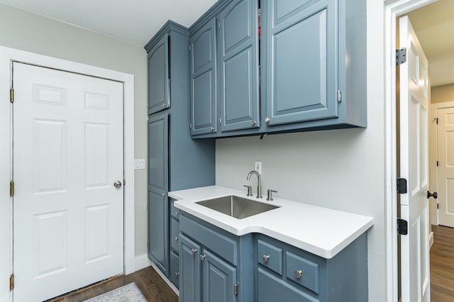 9420 Fabian St NE, Kalmar Twp, MN 55920 - laundry room featuring a sink, dark wood-style flooring, and baseboards