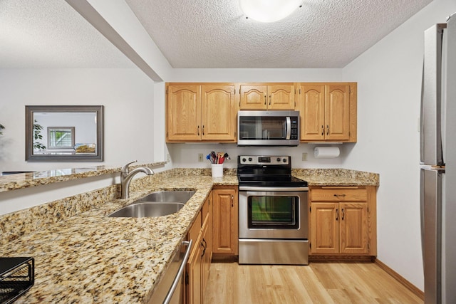 1925 Shenandoah Ct Unit G, Plymouth, MN 55447 - kitchen with appliances with stainless steel finishes, a sink, light wood-style floors, light stone countertops, and a textured ceiling