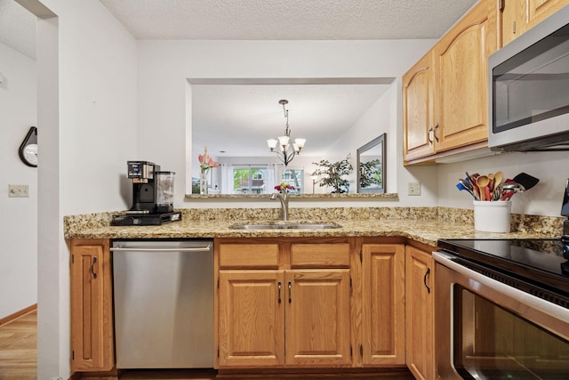 1925 Shenandoah Ct Unit G, Plymouth, MN 55447 - kitchen with appliances with stainless steel finishes, a sink, light stone counters, a chandelier, and wood finished floors