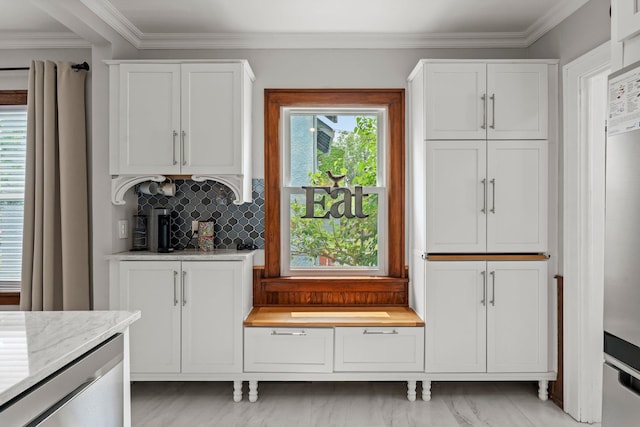 3812 Elliot Ave, Minneapolis, MN 55407 - kitchen featuring white cabinets, backsplash, ornamental molding, and light stone countertops