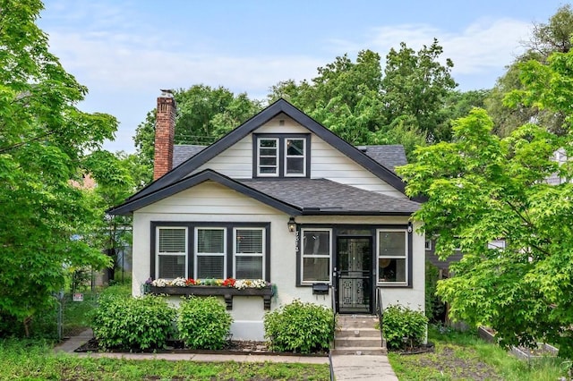 3812 Elliot Ave, Minneapolis, MN 55407 - bungalow with a shingled roof, a chimney, and stucco siding