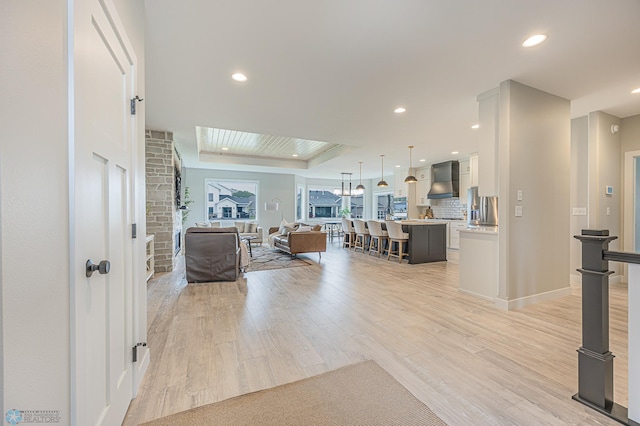 3340 2nd St E, West Fargo, ND 58078 - living area featuring light wood-style flooring, a tray ceiling, recessed lighting, and baseboards