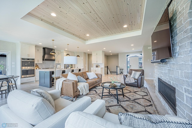 3340 2nd St E, West Fargo, ND 58078 - living room with a tray ceiling, recessed lighting, a stone fireplace, wood ceiling, and baseboards