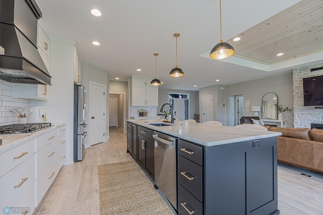 3340 2nd St E, West Fargo, ND 58078 - kitchen with a sink, appliances with stainless steel finishes, custom exhaust hood, light wood-style floors, and white cabinets