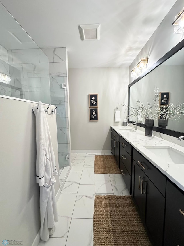 3340 2nd St E, West Fargo, ND 58078 - bathroom featuring marble finish floors, a tile shower, double vanity, and baseboards