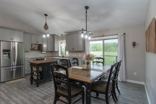7903 Long Lake Bay Rd, Brainerd, MN 56401 - dining space featuring light wood-type flooring, vaulted ceiling, and baseboards