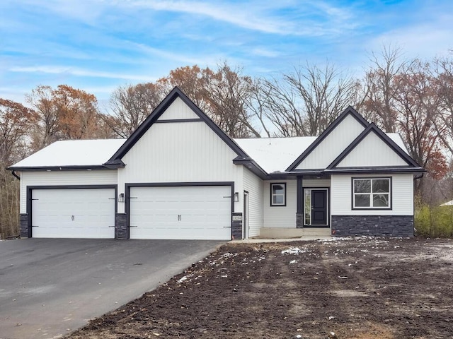 967 206th Ave NW, Oak Grove, MN 55011 - view of front facade with an attached garage, stone siding, and asphalt driveway