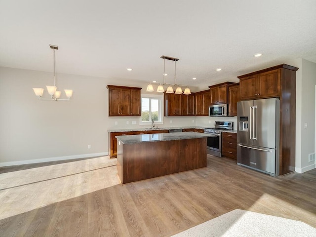 967 206th Ave NW, Oak Grove, MN 55011 - kitchen featuring stainless steel appliances, a center island, light wood-style floors, a chandelier, and baseboards