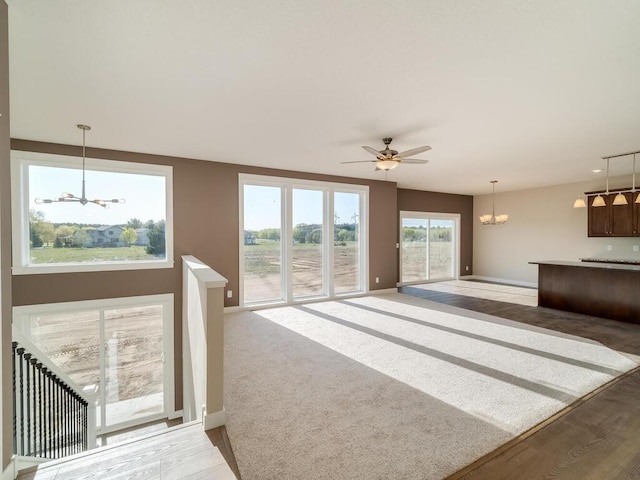 967 206th Ave NW, Oak Grove, MN 55011 - unfurnished living room featuring a chandelier, a ceiling fan, baseboards, and light wood-style floors