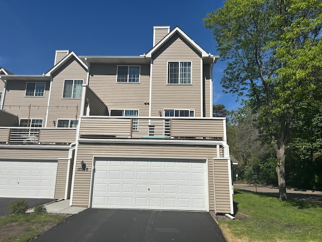 10946 Johnson St NE, Blaine, MN 55434 - view of front facade with a chimney, a balcony, driveway, and a garage