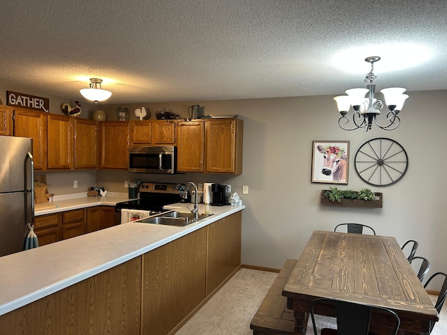 10946 Johnson St NE, Blaine, MN 55434 - kitchen with appliances with stainless steel finishes, brown cabinetry, a sink, a chandelier, and a textured ceiling