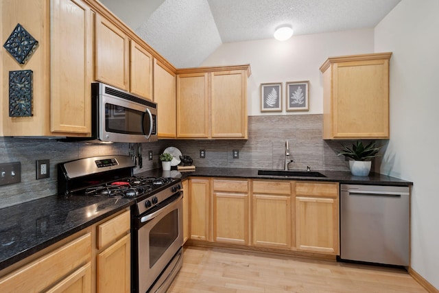 2658 133rd St W, Rosemount, MN 55068 - kitchen featuring appliances with stainless steel finishes, a sink, light brown cabinetry, lofted ceiling, and a textured ceiling