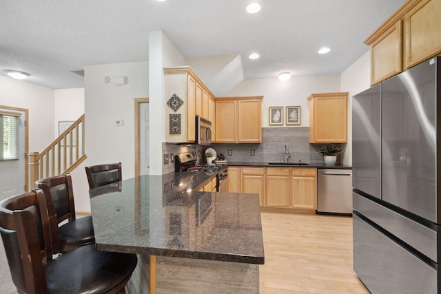 2658 133rd St W, Rosemount, MN 55068 - kitchen with appliances with stainless steel finishes, light brown cabinets, a peninsula, a sink, and tasteful backsplash