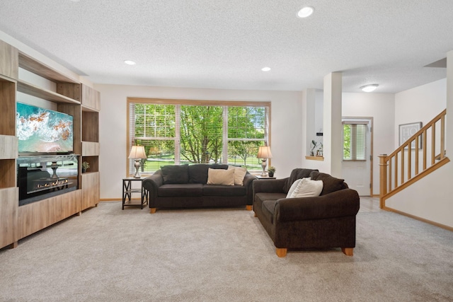 2658 133rd St W, Rosemount, MN 55068 - living room with light colored carpet, a textured ceiling, a glass covered fireplace, stairway, and recessed lighting
