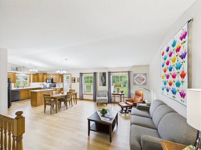625 7th St NW, Richmond, MN 56368 - living room featuring a chandelier, light wood-style flooring, and lofted ceiling