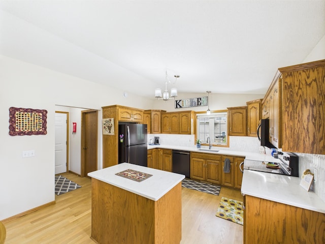 625 7th St NW, Richmond, MN 56368 - kitchen with black appliances, a sink, vaulted ceiling, brown cabinetry, and a chandelier