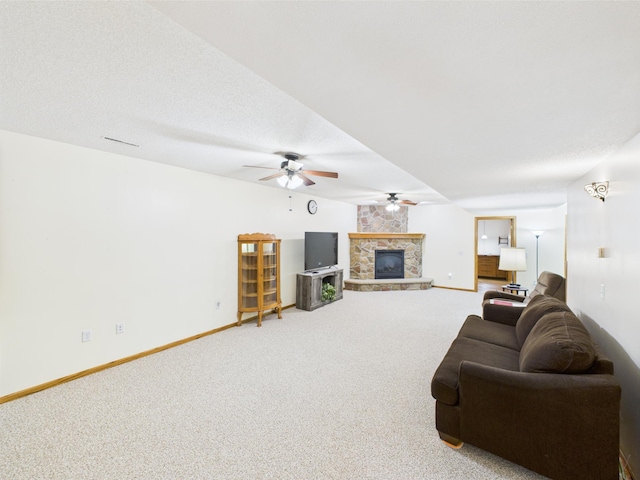 625 7th St NW, Richmond, MN 56368 - carpeted living room featuring a stone fireplace, ceiling fan, and baseboards
