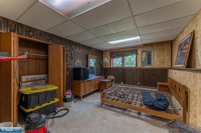 3240 Breezy Point Rd, Tower, MN 55790 - office featuring unfinished concrete floors, a paneled ceiling, wooden walls, a baseboard radiator, and electric panel