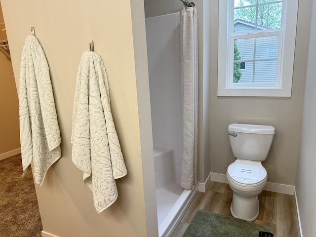105 7th St, Hoffman, MN 56339 - bathroom featuring a shower stall, baseboards, toilet, and wood finished floors