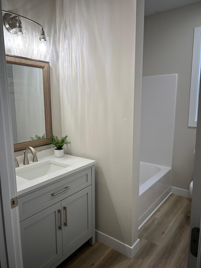 105 7th St, Hoffman, MN 56339 - bathroom with wood finished floors, vanity, baseboards, and toilet