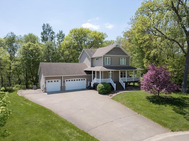16918 Van Buren St NE, Ham Lake, MN 55304 - view of front of home featuring covered porch, a garage, concrete driveway, a front lawn, and a shingled roof