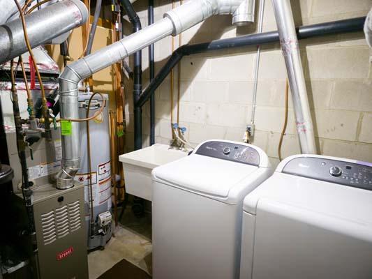 9826 Brighton Ln, Eden Prairie, MN 55347 - washroom with washer and clothes dryer, gas water heater, and concrete block wall