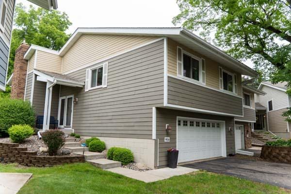 9826 Brighton Ln, Eden Prairie, MN 55347 - view of side of property with a garage, a chimney, and asphalt driveway
