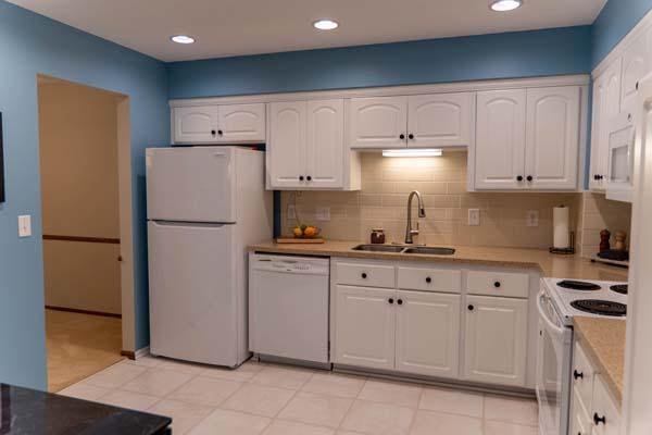 9826 Brighton Ln, Eden Prairie, MN 55347 - kitchen with white appliances, white cabinets, tasteful backsplash, light countertops, and recessed lighting