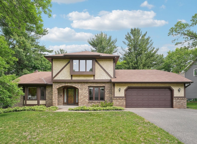 669 Lake Pine Dr, Shoreview, MN 55126 - tudor house featuring asphalt driveway, an attached garage, a front lawn, and brick siding