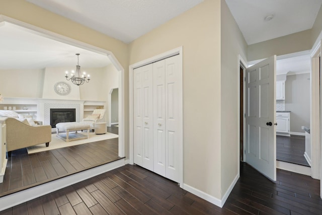 669 Lake Pine Dr, Shoreview, MN 55126 - foyer entrance featuring baseboards, dark wood finished floors, a chandelier, a tiled fireplace, and arched walkways