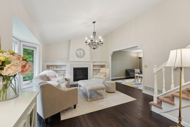 669 Lake Pine Dr, Shoreview, MN 55126 - living room with dark wood finished floors, a tiled fireplace, a chandelier, vaulted ceiling, and baseboards