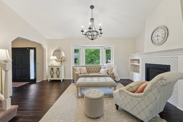 669 Lake Pine Dr, Shoreview, MN 55126 - living room featuring dark wood-type flooring, a chandelier, lofted ceiling, a tiled fireplace, and baseboards