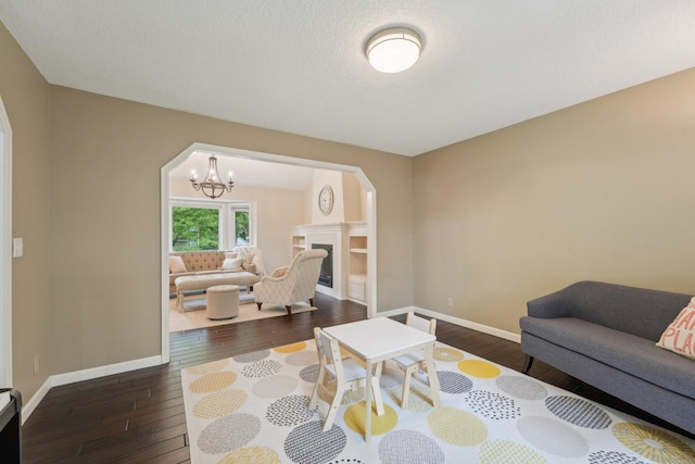 669 Lake Pine Dr, Shoreview, MN 55126 - living room featuring wood-type flooring, arched walkways, baseboards, a chandelier, and a fireplace
