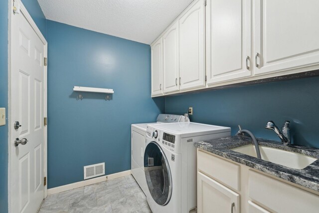 669 Lake Pine Dr, Shoreview, MN 55126 - laundry room featuring washer and clothes dryer, cabinet space, baseboards, and a textured ceiling