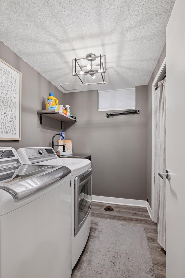 18201 Kathleene Dr, Minnetonka, MN 55345 - laundry area with washer and clothes dryer, wood finished floors, a textured ceiling, and baseboards