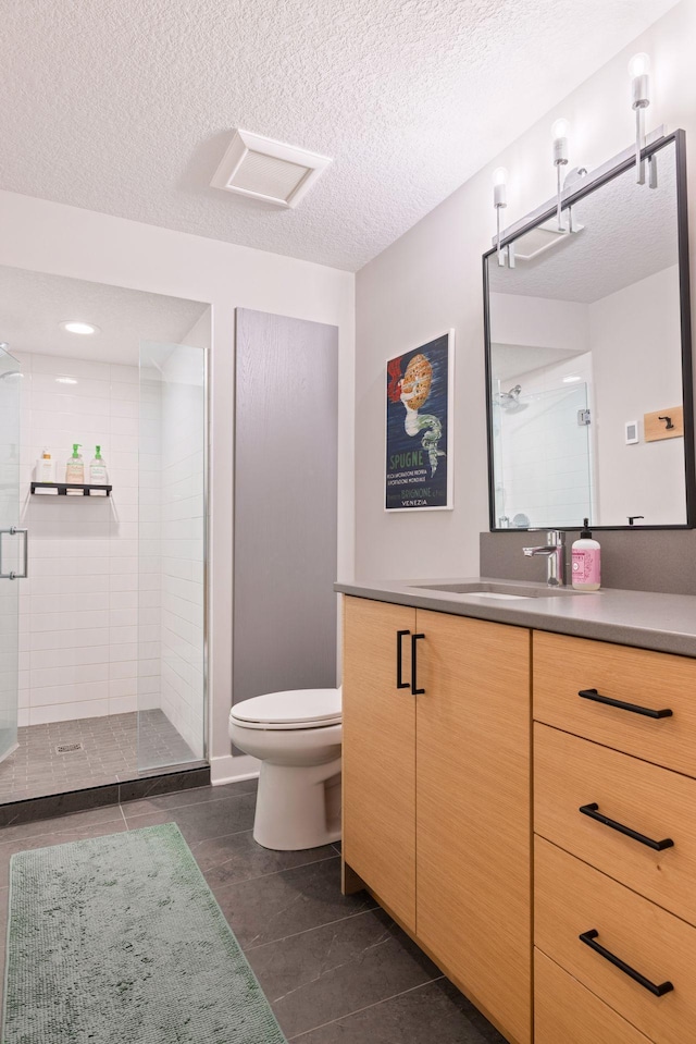 18201 Kathleene Dr, Minnetonka, MN 55345 - bathroom featuring vanity, a shower stall, toilet, a textured ceiling, and tile patterned floors
