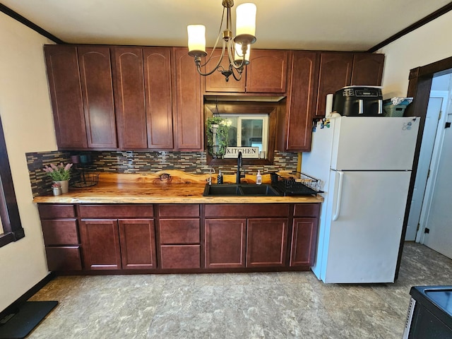 205 2nd Ave W, Lamberton, MN 56152 - kitchen featuring freestanding refrigerator, a sink, tasteful backsplash, a chandelier, and pendant lighting