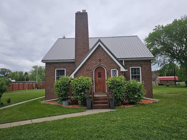 205 2nd Ave W, Lamberton, MN 56152 - tudor house with brick siding, a chimney, and metal roof