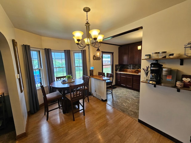 205 2nd Ave W, Lamberton, MN 56152 - dining space with a chandelier, dark wood-style floors, arched walkways, and baseboards