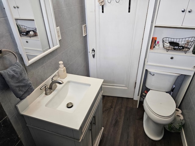 205 2nd Ave W, Lamberton, MN 56152 - half bathroom featuring tile walls, wood finished floors, vanity, and toilet