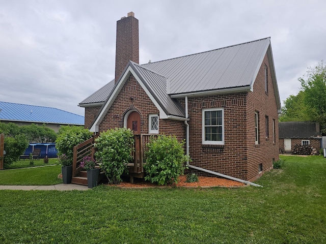 205 2nd Ave W, Lamberton, MN 56152 - tudor-style house featuring a chimney, brick siding, and a front yard