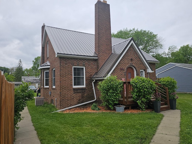 205 2nd Ave W, Lamberton, MN 56152 - tudor-style house featuring a chimney, brick siding, metal roof, and central air condition unit