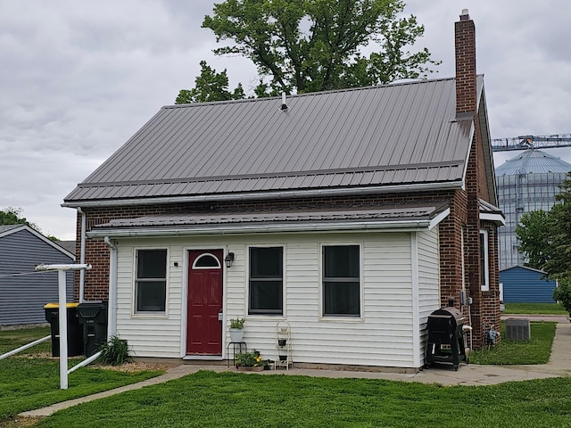 205 2nd Ave W, Lamberton, MN 56152 - view of front facade featuring a chimney, a front lawn, metal roof, and central AC unit