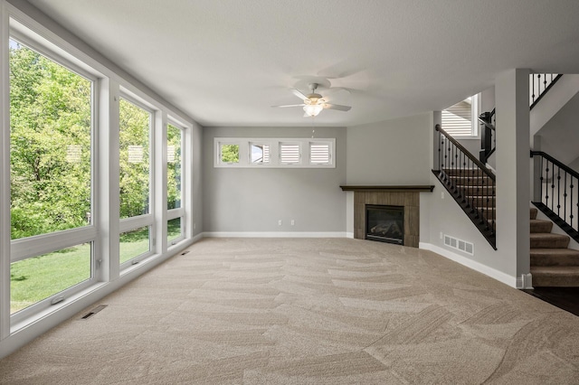 1206 Rosemary Ln, Chaska, MN 55318 - unfurnished living room featuring baseboards, carpet floors, stairway, ceiling fan, and a tile fireplace